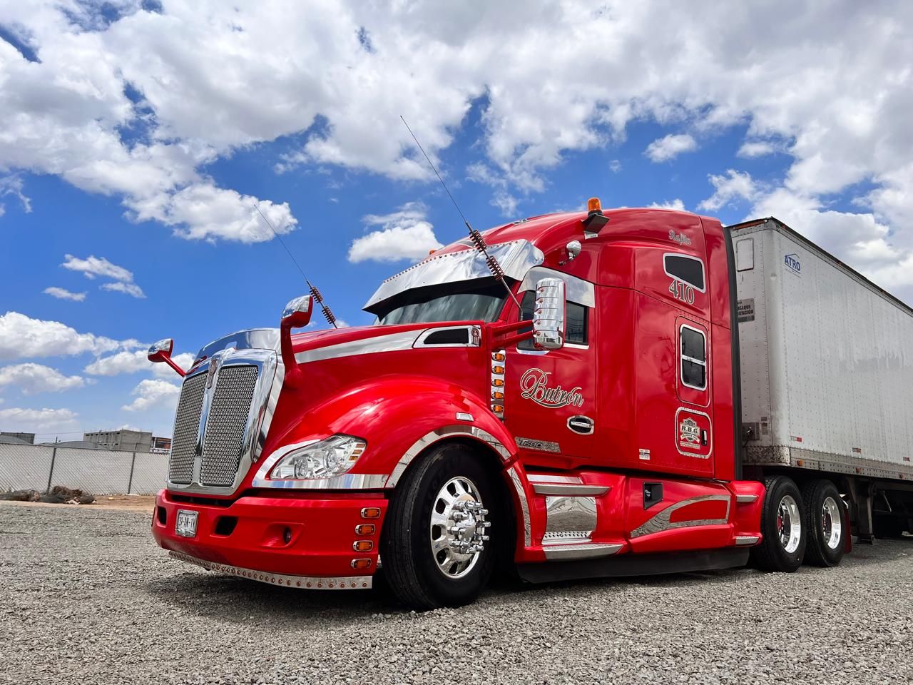Tractocamión Kenworth rojo con caja seca, rotulado con la caligrafía Butrón en la puerta